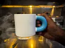 Cinematic product advertisement showing _mug_ being held by a right hand in a natural position in an elegant, modern kitchen setting. Low-key, moody lighting with warm tones and soft shadows creating a luxurious and d.webp
